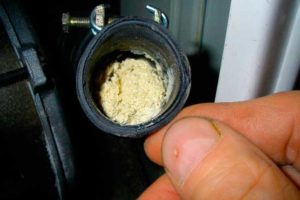 The washing machine drain hose is clogged with debris.